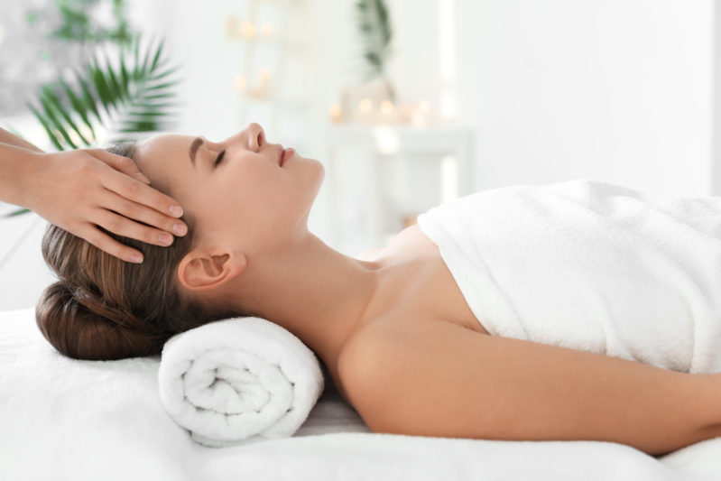 Joven que disfruta de un masaje en el salón de belleza